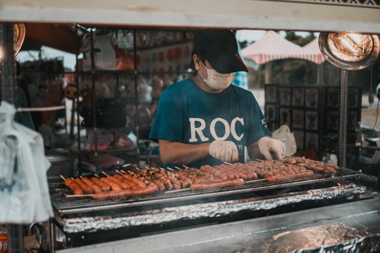 a person cooking sausages on a  grill