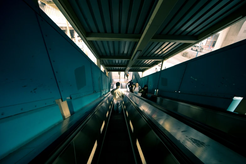 people riding on an escalator at a subway station