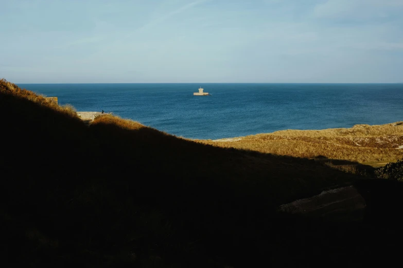 a boat on the ocean from a hill side