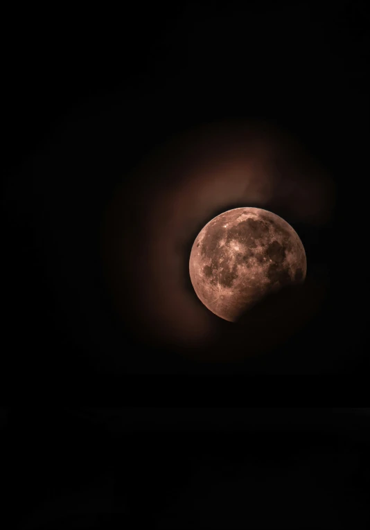 the full moon rising in a dark sky with only the light on