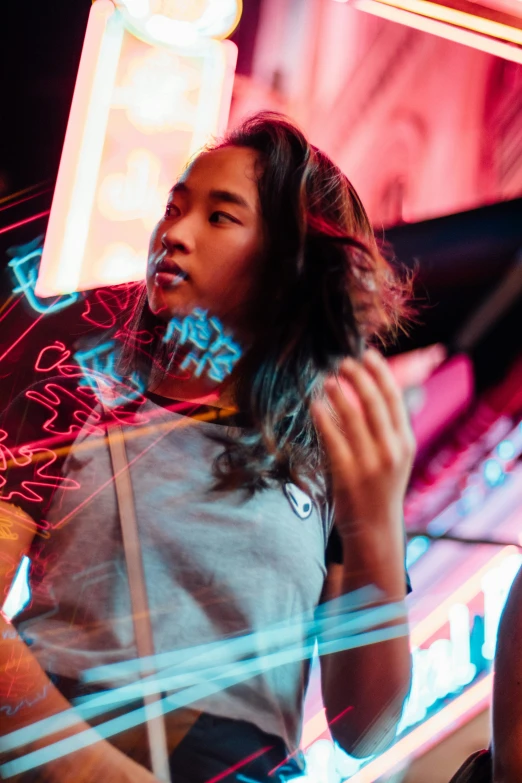 a woman standing next to a building and neon signs