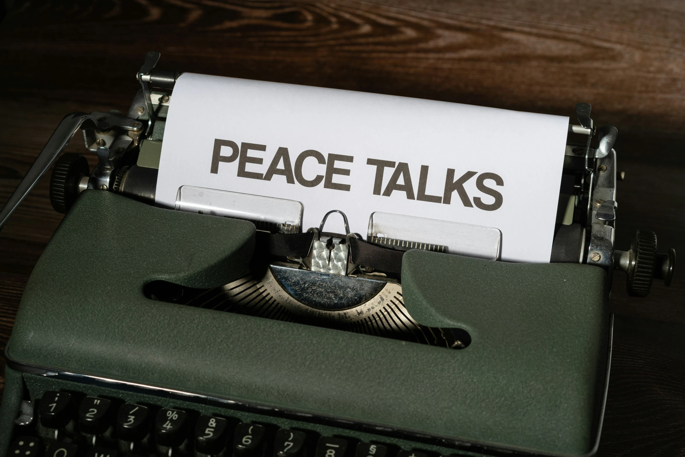 an old typewriter has paper that says peace talks