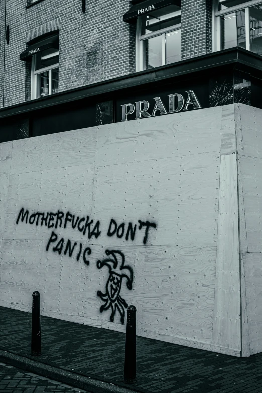 a graffitti wall with words that say, motherfucci don't panic prada