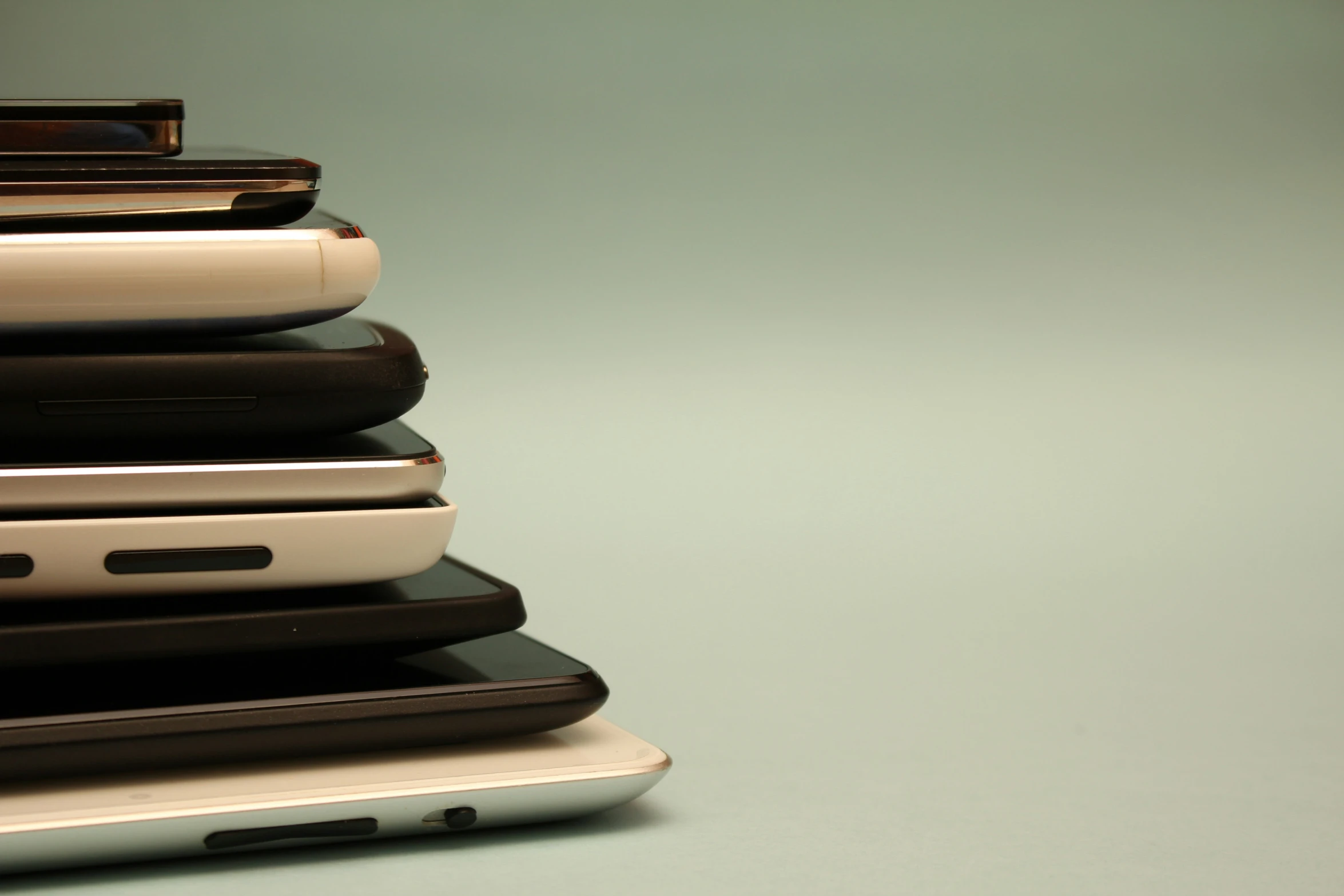 multiple different style of cell phones stacked on top of each other