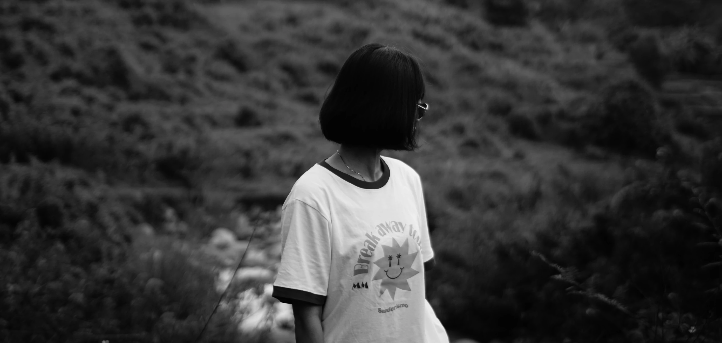 a person standing in the grass with a white t shirt on