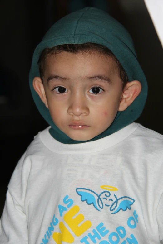 a small child wearing a white tee shirt with wings