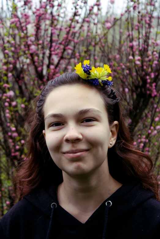 a young lady wearing some flower hair clips