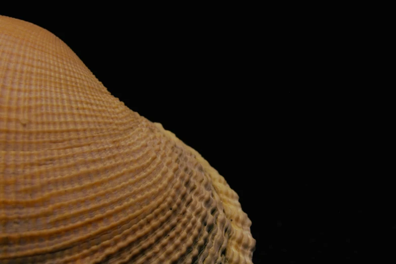 a light brown colored hat sitting on top of a black table