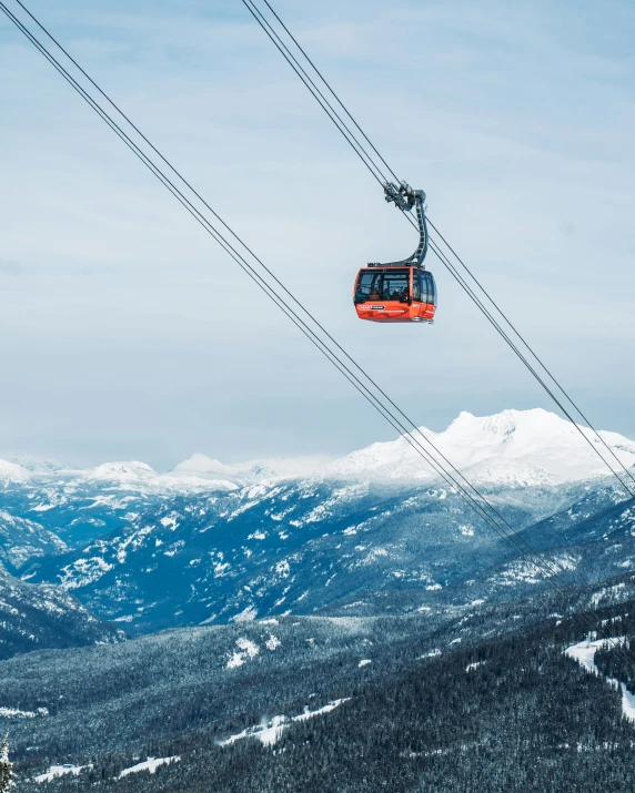 the ski lift is above the snow covered mountains