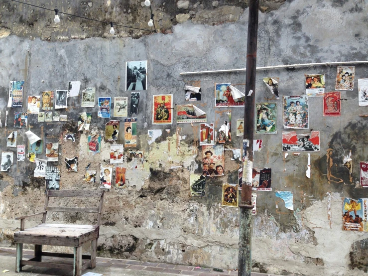 an image of a concrete building with various pictures posted on the wall