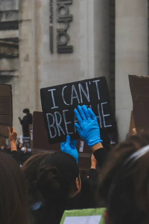 several people at a protest with signs reading i can't break me