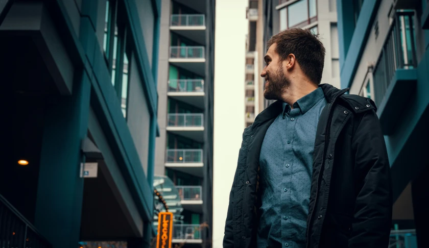 a man standing outside in a blue and black building