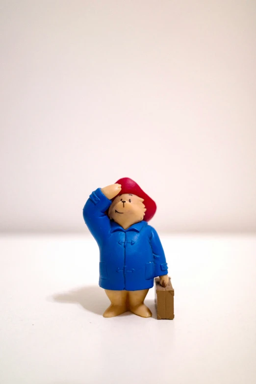 a plastic toy person that is wearing a blue coat