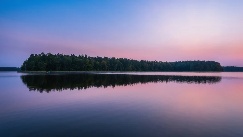 a very pretty sky over some water and trees