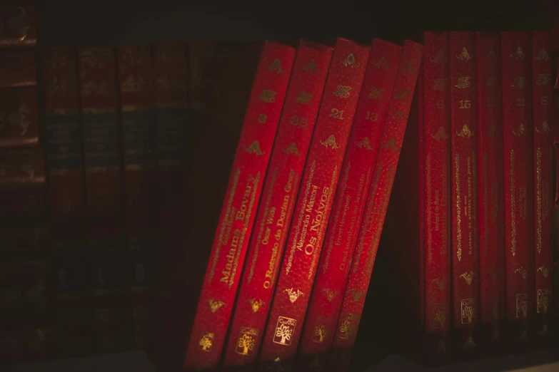 several red books lined up on a shelf