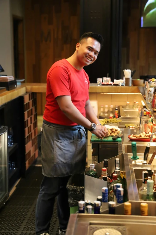 a man is smiling while standing at a food line