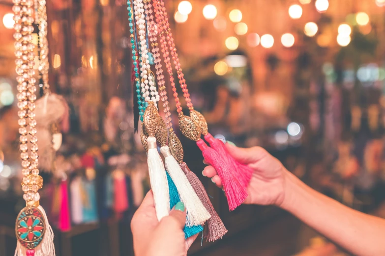 a person reaching up for beads attached to a necklace