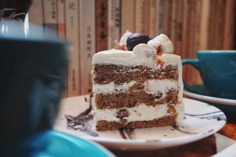 a piece of cake sitting on a table next to a blue mug