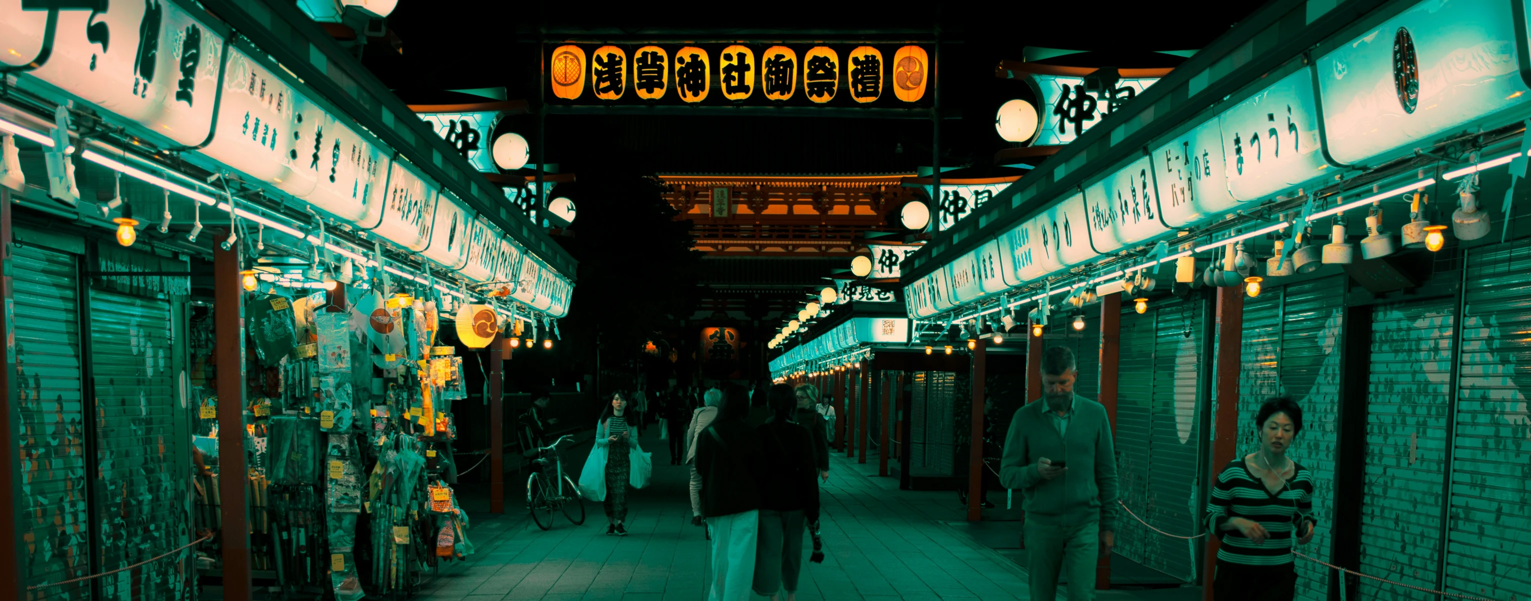 people walking along the outside of an asian market