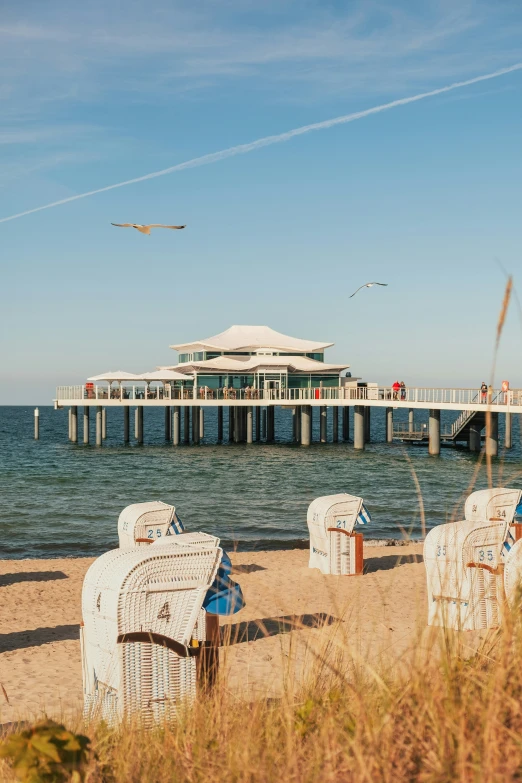 the chairs are in front of the beach and under the pier