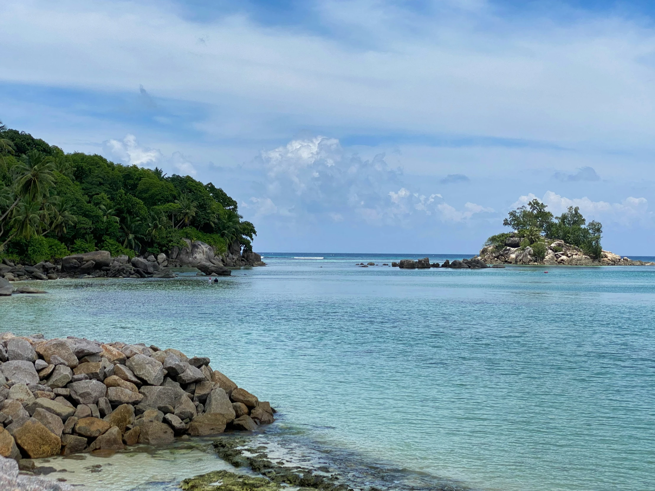 rocks in the ocean and a small island sitting on one of them