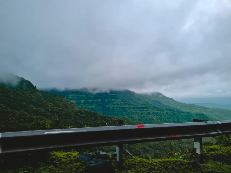 a couple of mountains are seen from behind a road