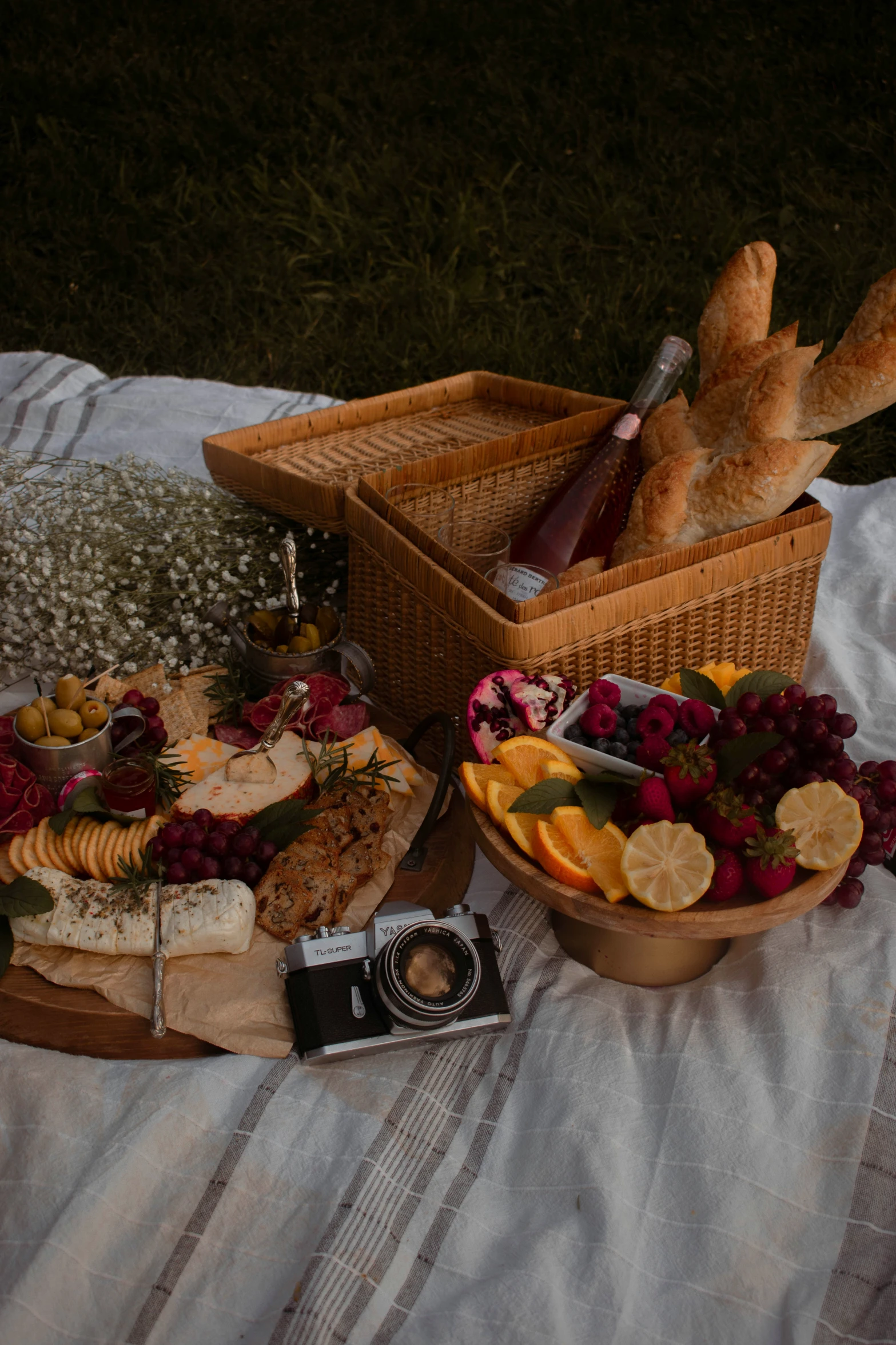 a picnic basket with bread, ers, fruit, and cheese