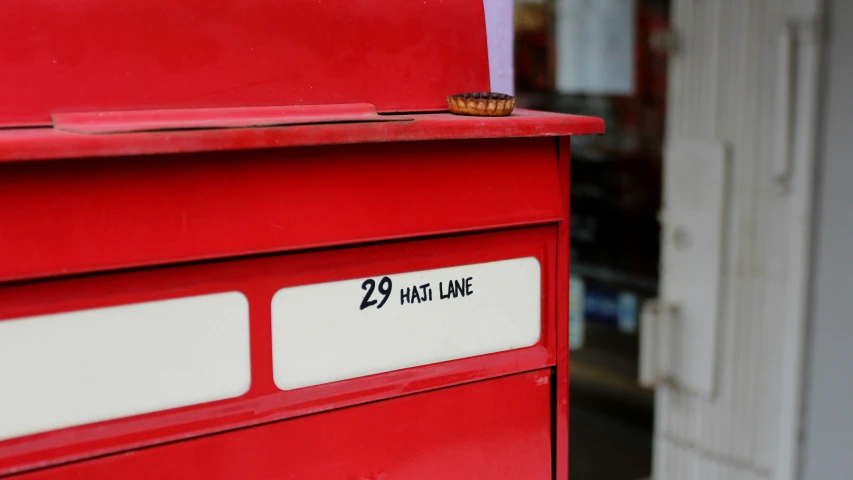 a close up of a red mailbox with writing on it