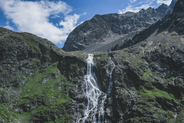 a large waterfall surrounded by lush green mountains