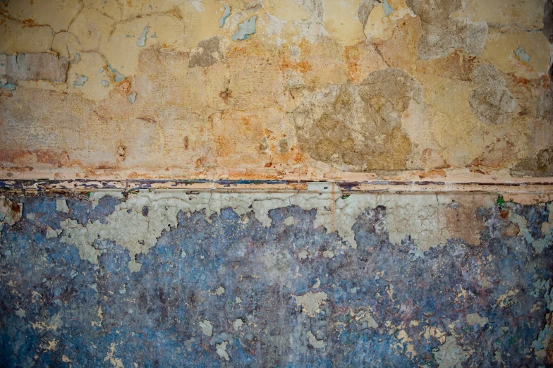 an old dirty wall with peeling paint and chipping