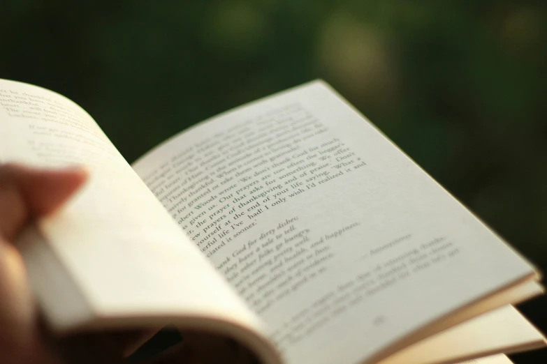 a close up image of a book being held in someone's hands