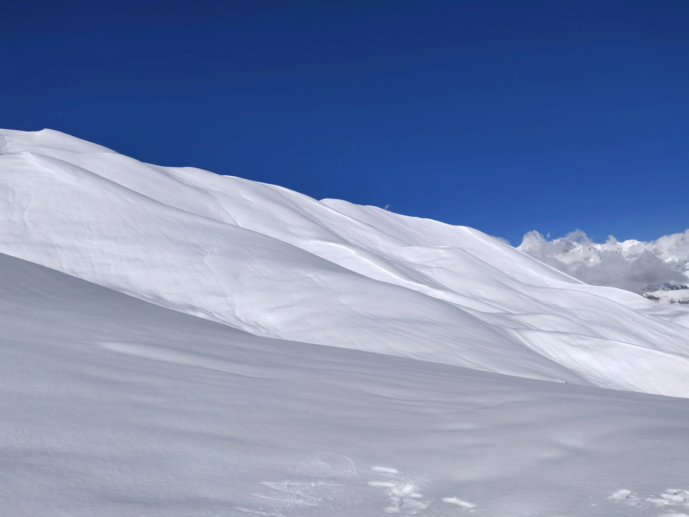 two skiers going down the snowy slope, with their skis up in the air