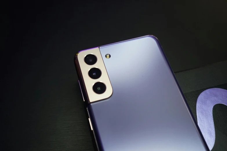 the back of a purple cell phone with a camera in its left hand