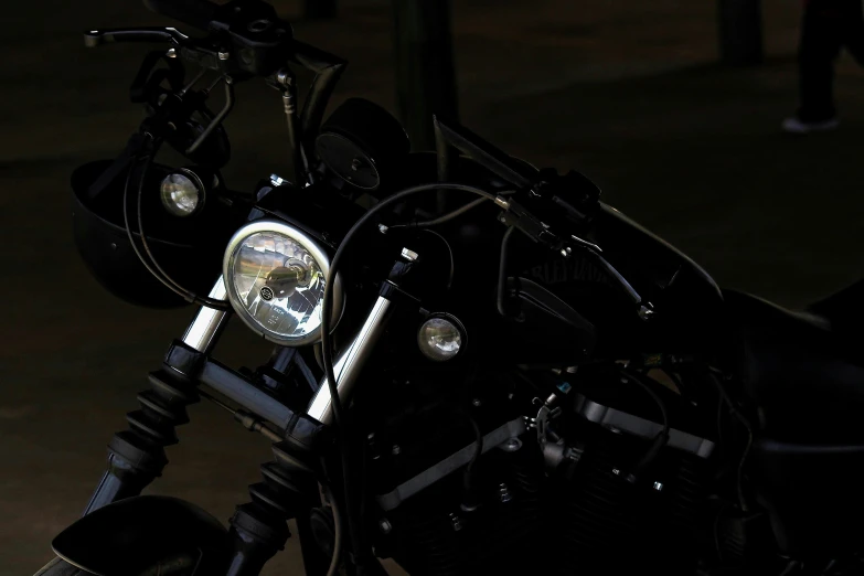 the front end of a black motorcycle parked in a parking lot