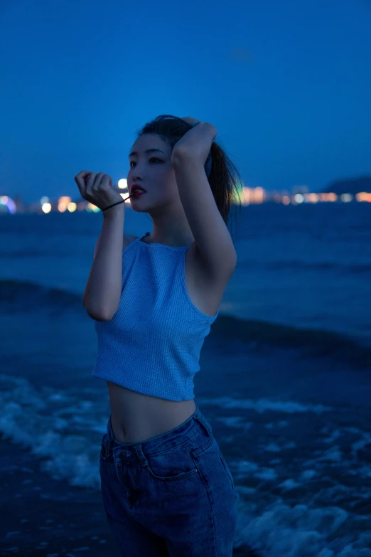 a girl with blue clothes is standing on the beach