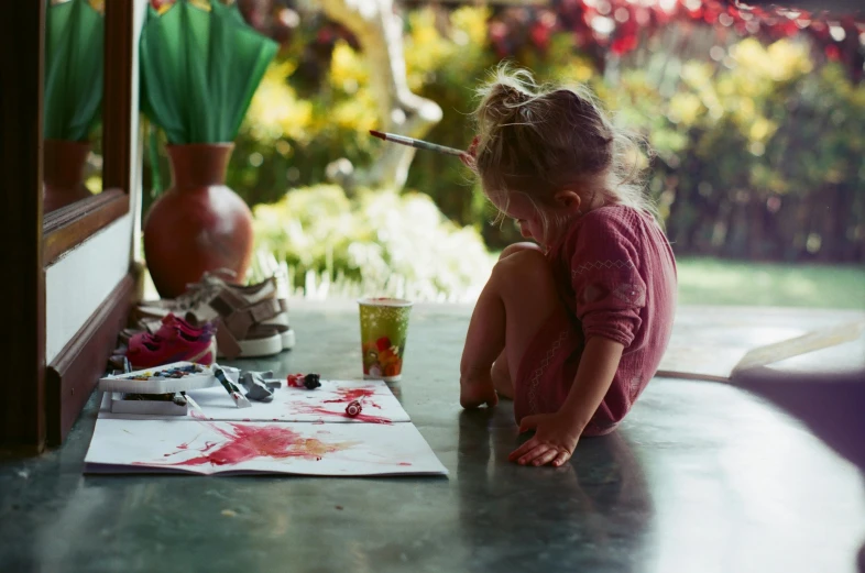 two little girls painting pictures on a table