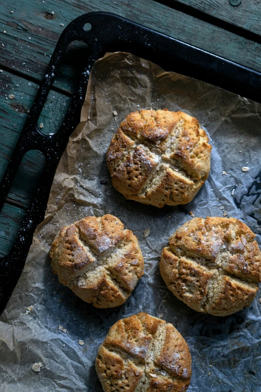 four round breads are shown on top of parchment paper