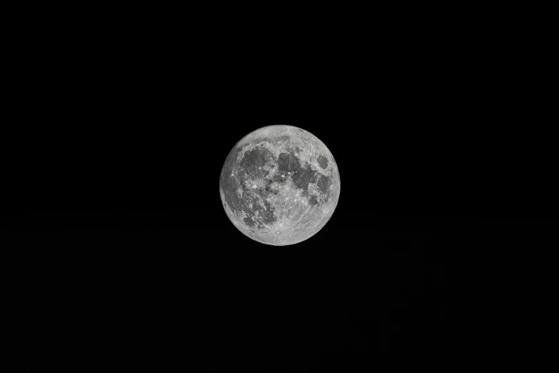 the moon shining in the black night sky