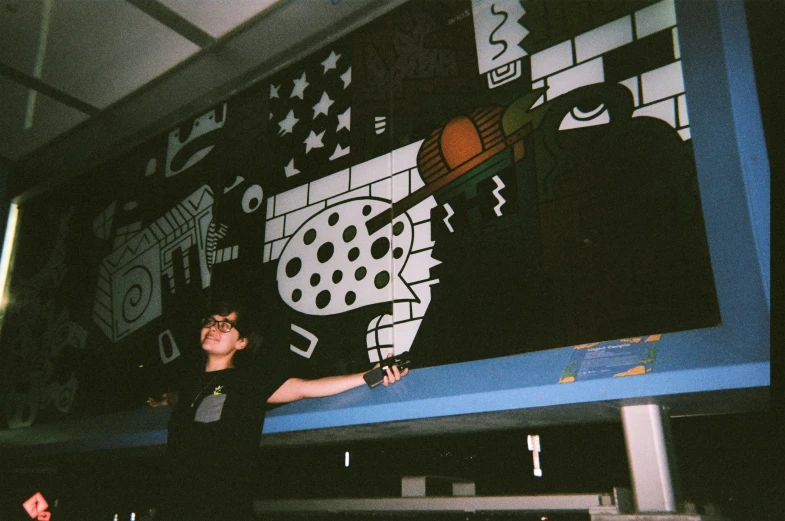 young man standing in front of a large painting