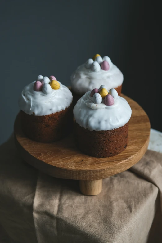 two cupcakes that are on top of a wooden platter