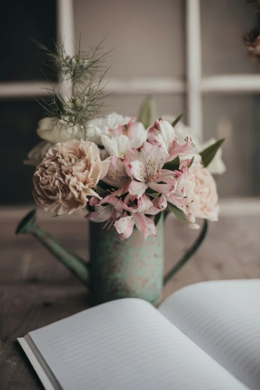 an open book is on a table with flowers