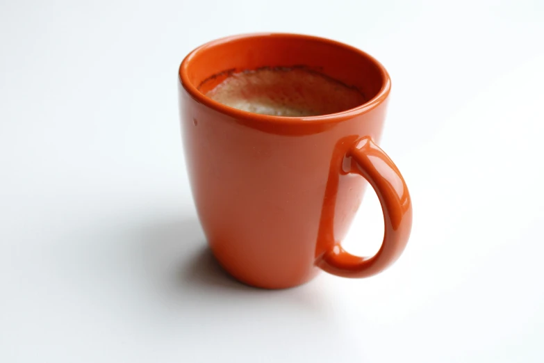 there is a bright orange cup on a table