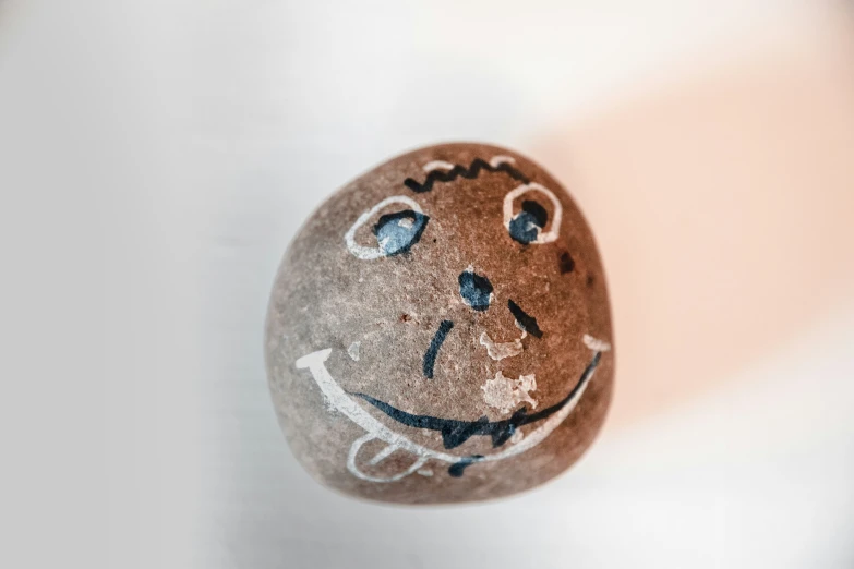 an easter egg with a smiling face is painted in brown