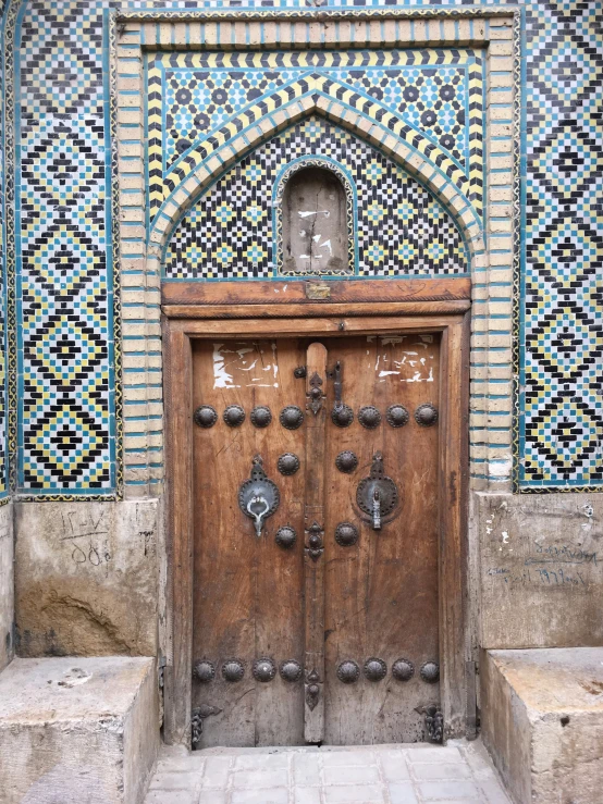 an intricately designed doorway with stone steps and tiles