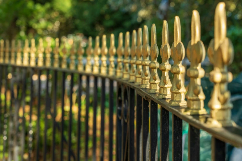 many gold colored candles are on top of a fence