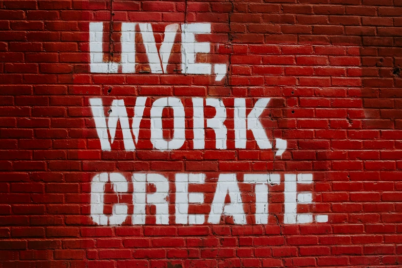 graffiti on brick wall depicting live, work, create