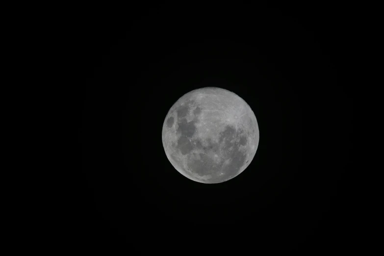 the moon is seen through the dark sky