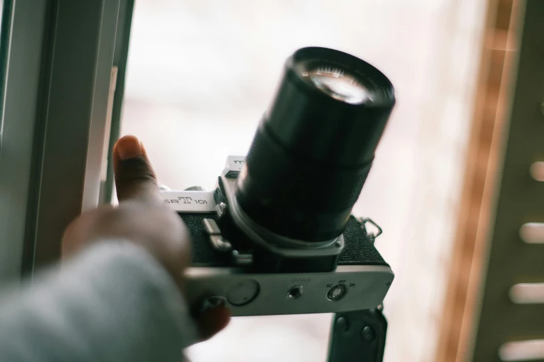the view from a window of a person holding a small camera
