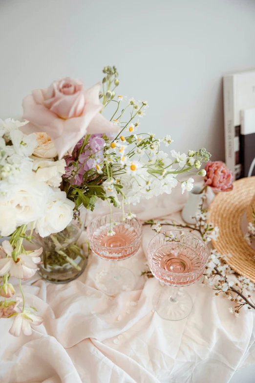 the white table cloth has pink glasses on it