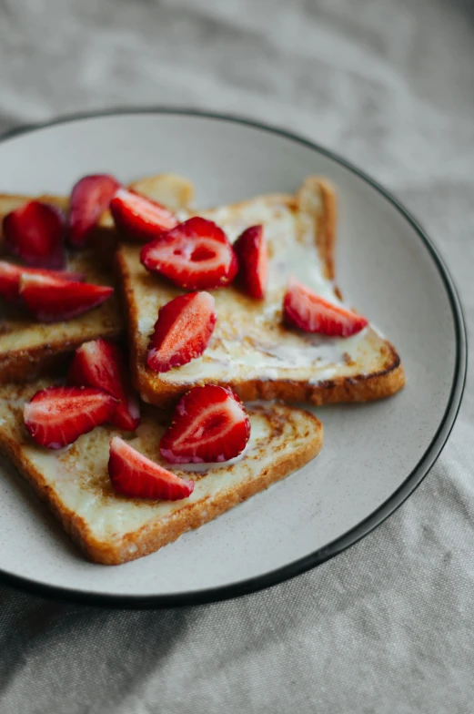 some toast and strawberries are on a white plate